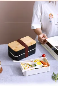 Detail of double-layer lunch box with bamboo lid, elastic band, and eco-friendly cutlery set