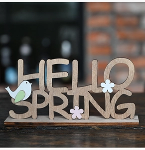 Détail du signe en bois Hello Spring avec oiseaux découpés et décorations florales