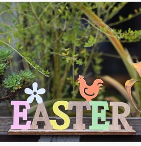 Détail de lettres de Pâques colorées en bois avec décor de coq pour décoration de table