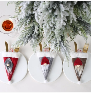 Porta cubiertos navideños de gnomo con barba y gorro en una mesa festiva decorada