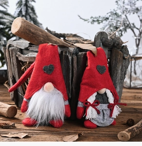 Detail of Christmas gnomes in red and grey felt with heart accents on wooden background