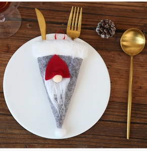 Detalle de porta cubiertos de gnomo de Navidad con gorro de corazón en plato blanco