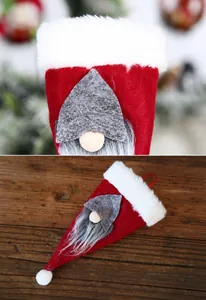 Primer plano de porta cubiertos de gnomo navideño hecho de terciopelo rojo y piel sintética