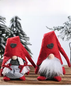 Detail view of handmade Christmas gnomes with heart patches on a rustic wooden surface