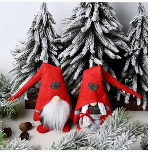 Pair of Christmas Gnomes with red felt hats and heart patterns in a snowy pine setting