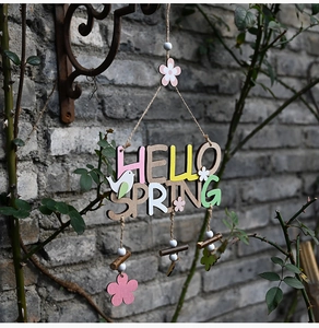 Detailed view of Hello Spring wooden door hanger with colorful flowers and bird ornaments
