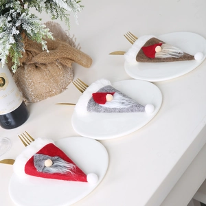 Portacubiertos navideños de fieltro en rojo, gris y marrón sobre platos blancos