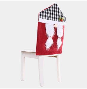 Dettaglio coprisedia natalizio con design a gnomo e cappello a scacchi su sedia bianca