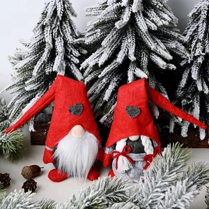 Pair of Christmas Gnomes plush toys with red hats and heart patches in a winter scene