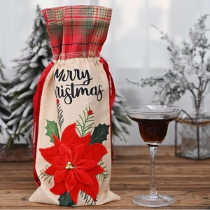 Macro shot of burlap wine bag with Merry Christmas text and large red poinsettia flower