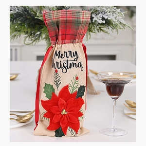 Detail of burlap Christmas wine bag with red poinsettia flower and Merry Christmas text