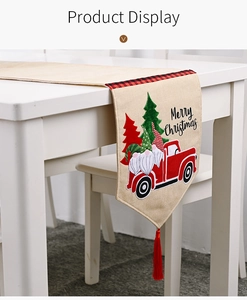Nahaufnahme eines rustikalen Weihnachts-Tischläufers mit rotem LKW und Gnomen-Motiv