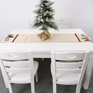 Weihnachtlicher Tischläufer mit Tannenbäumen und Karomuster auf einem weißen Esstisch