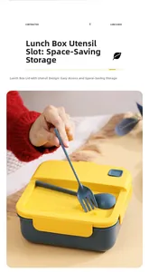 Detail view of the yellow lunch box lid with built-in storage for blue fork and spoon