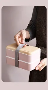 Detail der rosa doppellagigen Bento-Box mit Holzstruktur-Deckel und grauem Gummiband