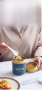 Close-up of dual-layer stainless steel breakfast cup in navy blue with a white spoon