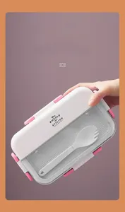 Detail of a portable pink and white lunch box with 4-side buckles and a built-in spoon