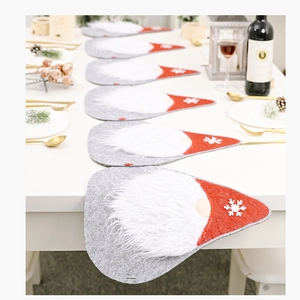 Close-up of gray felt Christmas gnome table placemats with white snowflakes on red hats