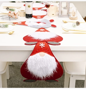Close-up of red Christmas gnome table runner with white snowflake embroidery and felt details