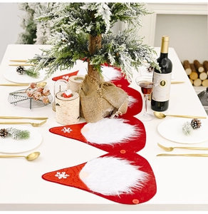 Close-up of red felt Christmas table runner with plush white beard and snowflake detail