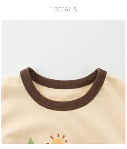 Detail of child T-shirt with brown ribbed crew neck and sun print on beige cotton