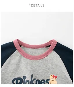 Detailed view of kids' raglan T-shirt featuring pink ribbed collar and cute bear print