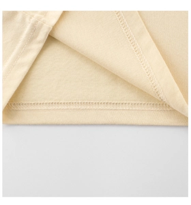 Detailed close-up of double-needle hem stitching on high-quality cream cotton fabric
