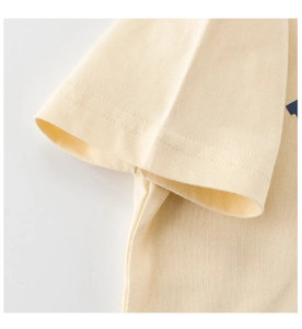 Détail du tissu en coton crème avec des coutures à double aiguille sur la manche de l'enfant