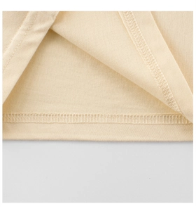 Détail de l'ourlet du t-shirt pour enfants montrant la couture de qualité et la texture du tissu