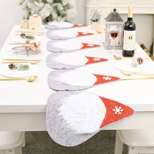 Christmas table runner with faceless gnome design and red sequin hats on a white table