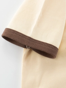 Kids cream cotton t-shirt featuring dark brown ribbed cuff detail and textured fabric