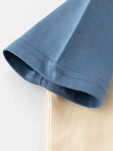 Macro view of blue cotton T-shirt sleeve cuff with durable double stitching detail