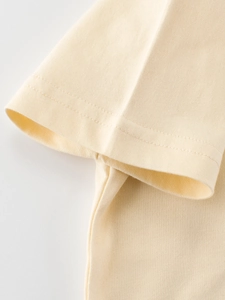 Gros plan d'une manche de t-shirt en coton pour enfant avec double couture soignée