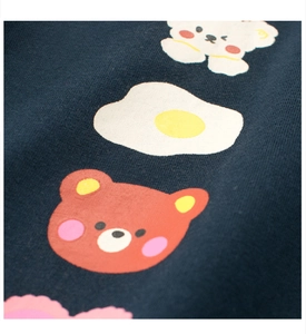Macro detail of cartoon bear and egg prints on high-quality navy cotton fabric