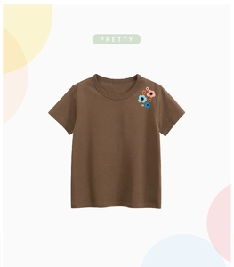 Detail of brown cotton kids T-shirt featuring colorful floral embroidery on the chest