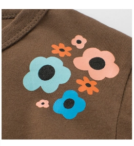 Detail of colorful flower prints and neckline stitching on dark brown cotton t-shirt