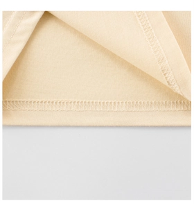 Detailed close-up of double-needle stitching on cream cotton baby T-shirt hem