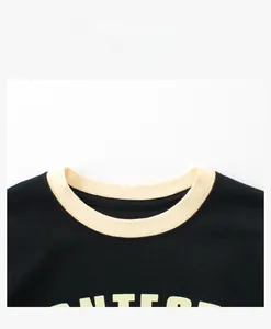 Détail d'un t-shirt à col rond avec col côtelé ivoire et tissu en coton noir de qualité