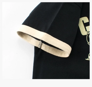 Détail du t-shirt noir en coton avec bord-côte beige et imprimé de la lettre G