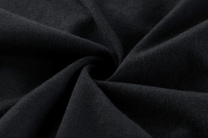 Vue macro d'un tissu en coton tricoté noir doux avec des détails de pliage en spirale