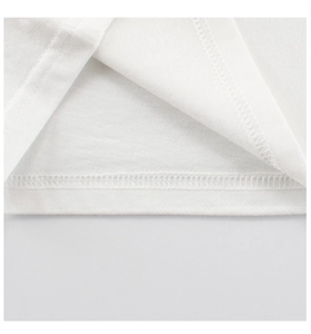 Close-up of double-needle stitching and fine cotton texture on white toddler shirt