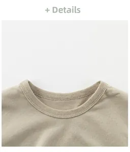 Close-up of the beige knit cotton t-shirt neckline showing refined double-needle stitching details