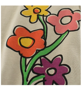 Close-up of vibrant floral doodle print on soft beige cotton knit fabric for girls