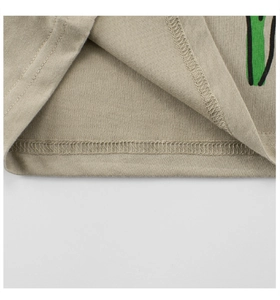 Detailed close-up of hem stitching and floral print on beige cotton t-shirt fabric