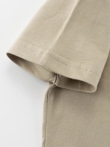 Close-up of khaki cotton T-shirt sleeve with reinforced double-needle stitching detail