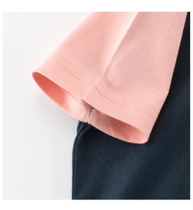 Dettaglio della cucitura tra manica rosa e corpo blu navy con doppia impuntura su cotone