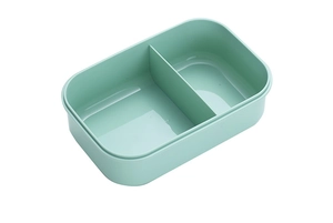 Macro view of mint green two-compartment lunch box with durable plastic interior