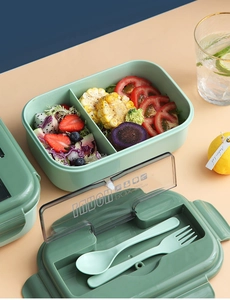 Close-up of Morandi green 2-compartment lunch box with built-in cutlery set on lifestyle background