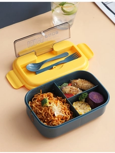 Close-up of dual-compartment lunch box showing organized food and plastic cutlery set
