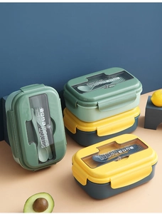 Close-up of portable dual-compartment lunch box with built-in utensils and clear lid